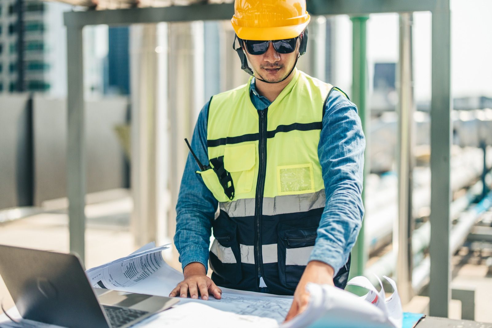 Planer prüft Pläne auf der Baustelle